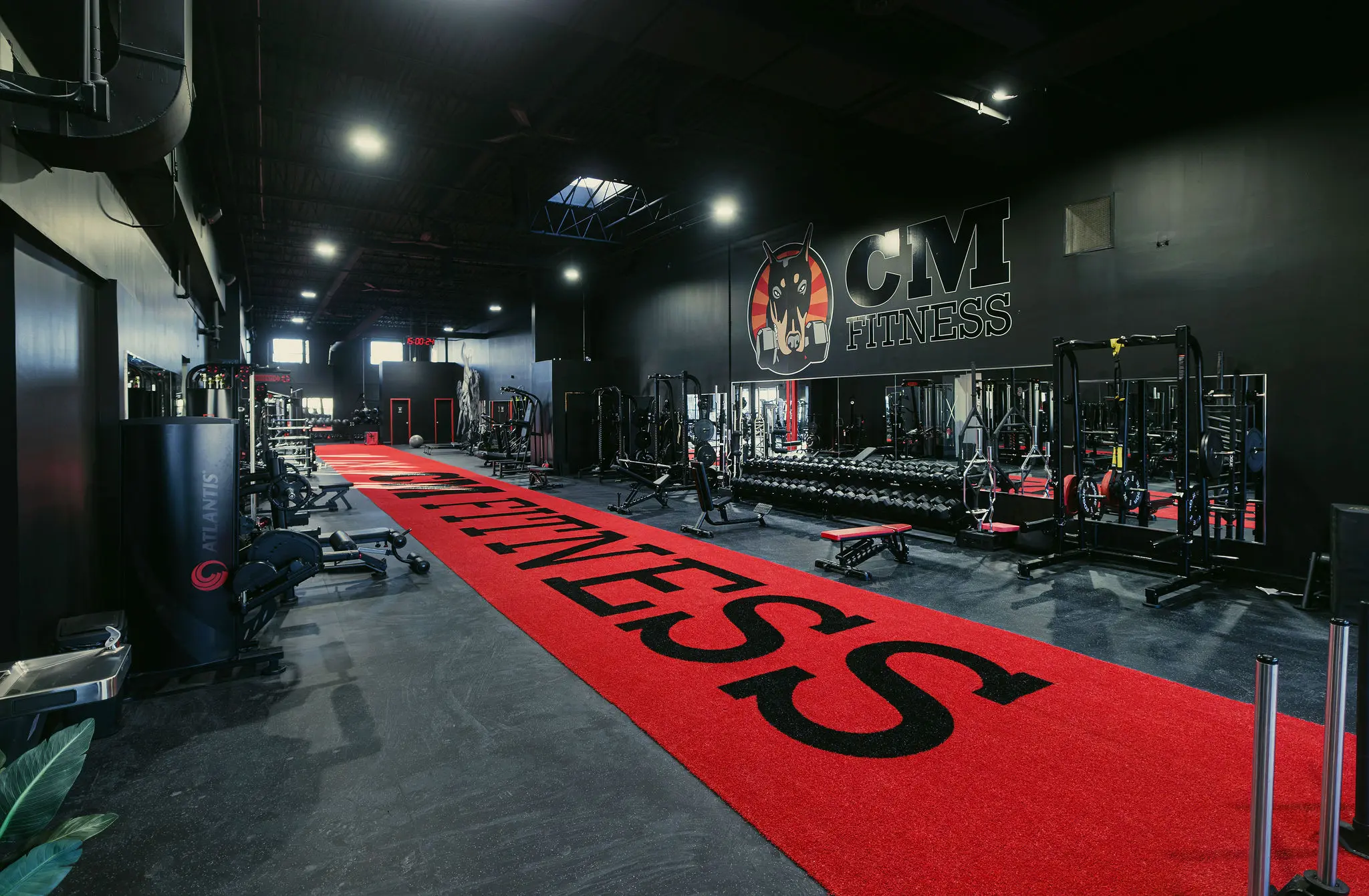 Voie de turf rouge avec logo CM Fitness dans un gym commercial
